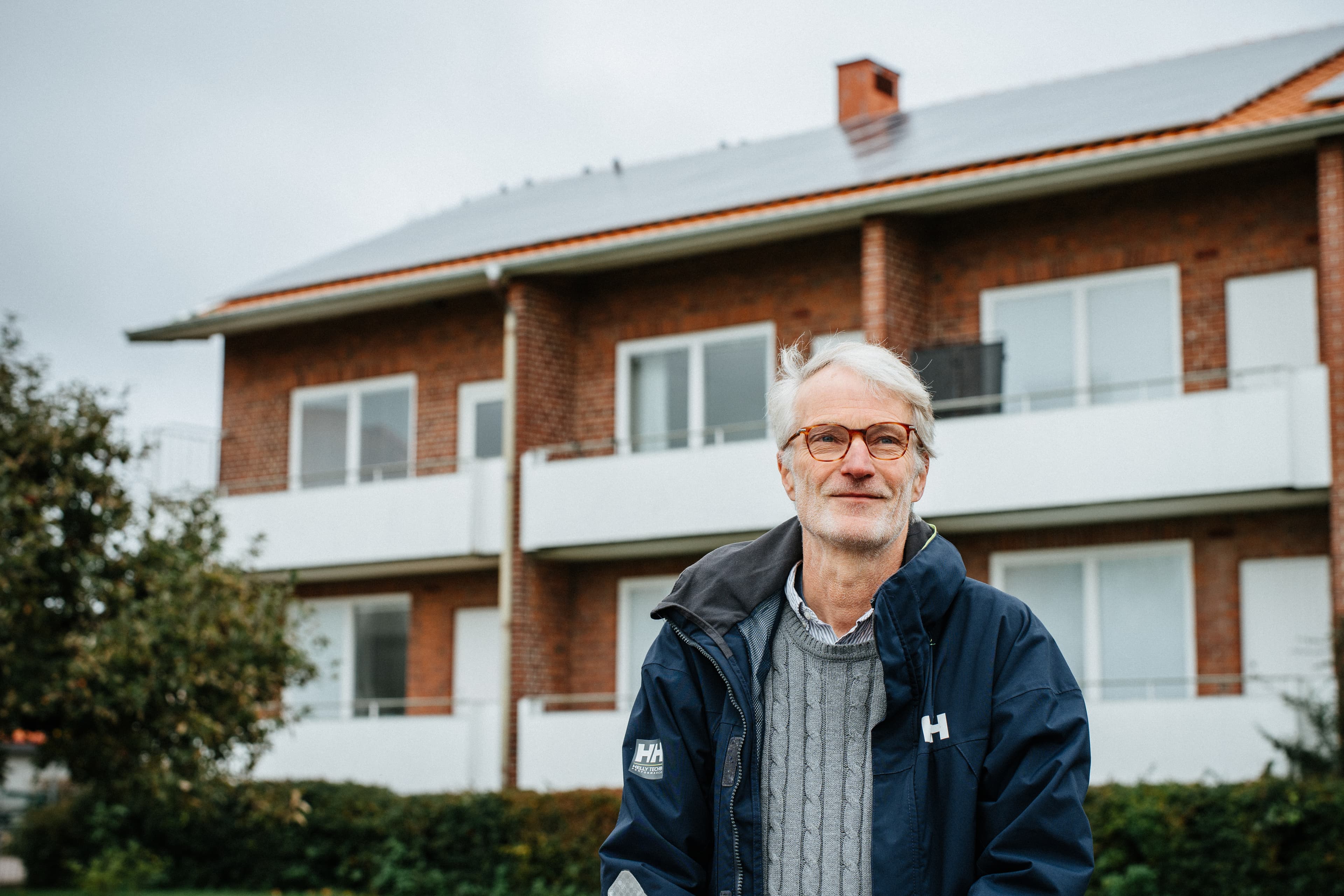 Man står framför hus med solpaneler på taket