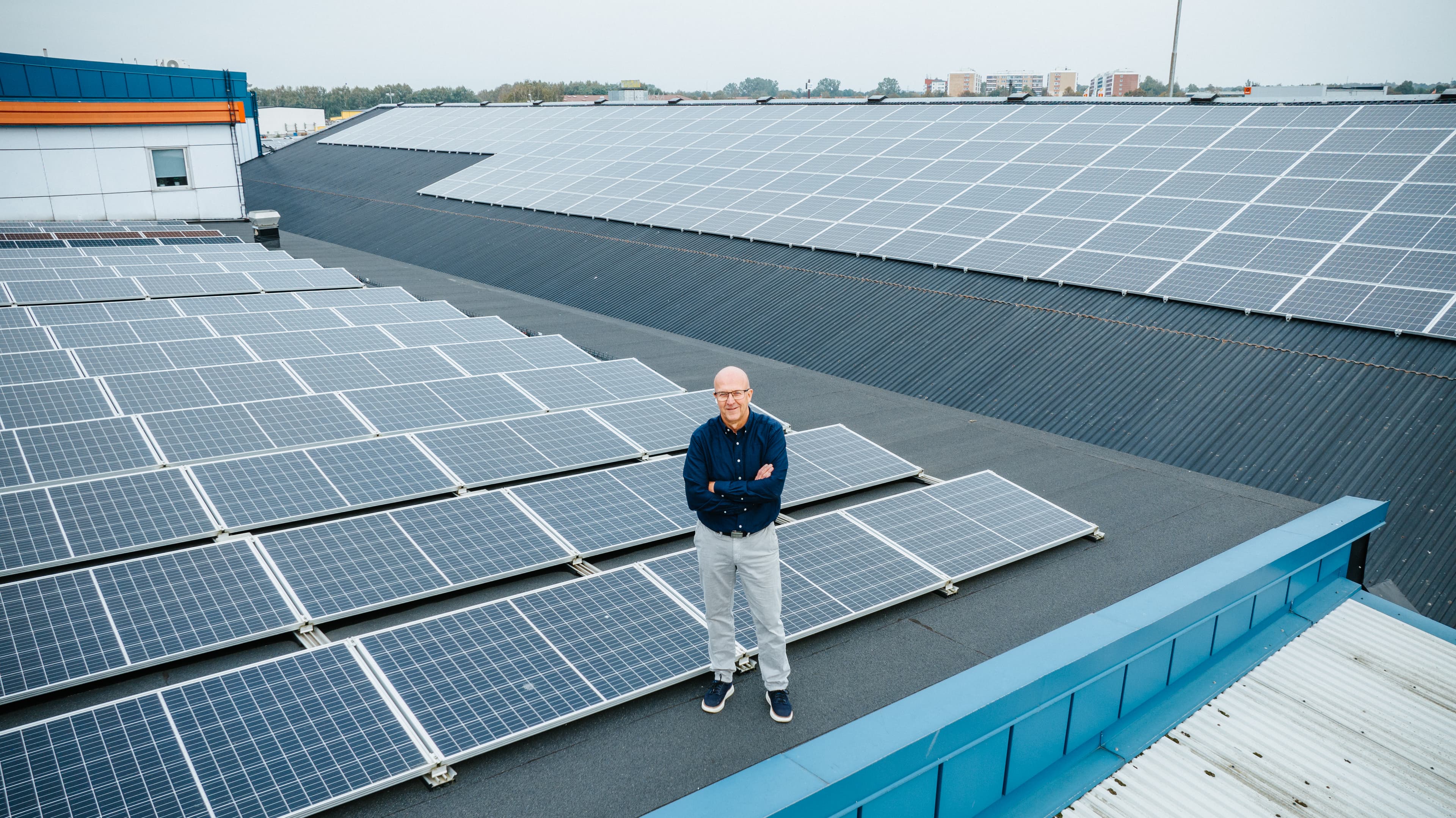 Man står framför solpaneler på taket