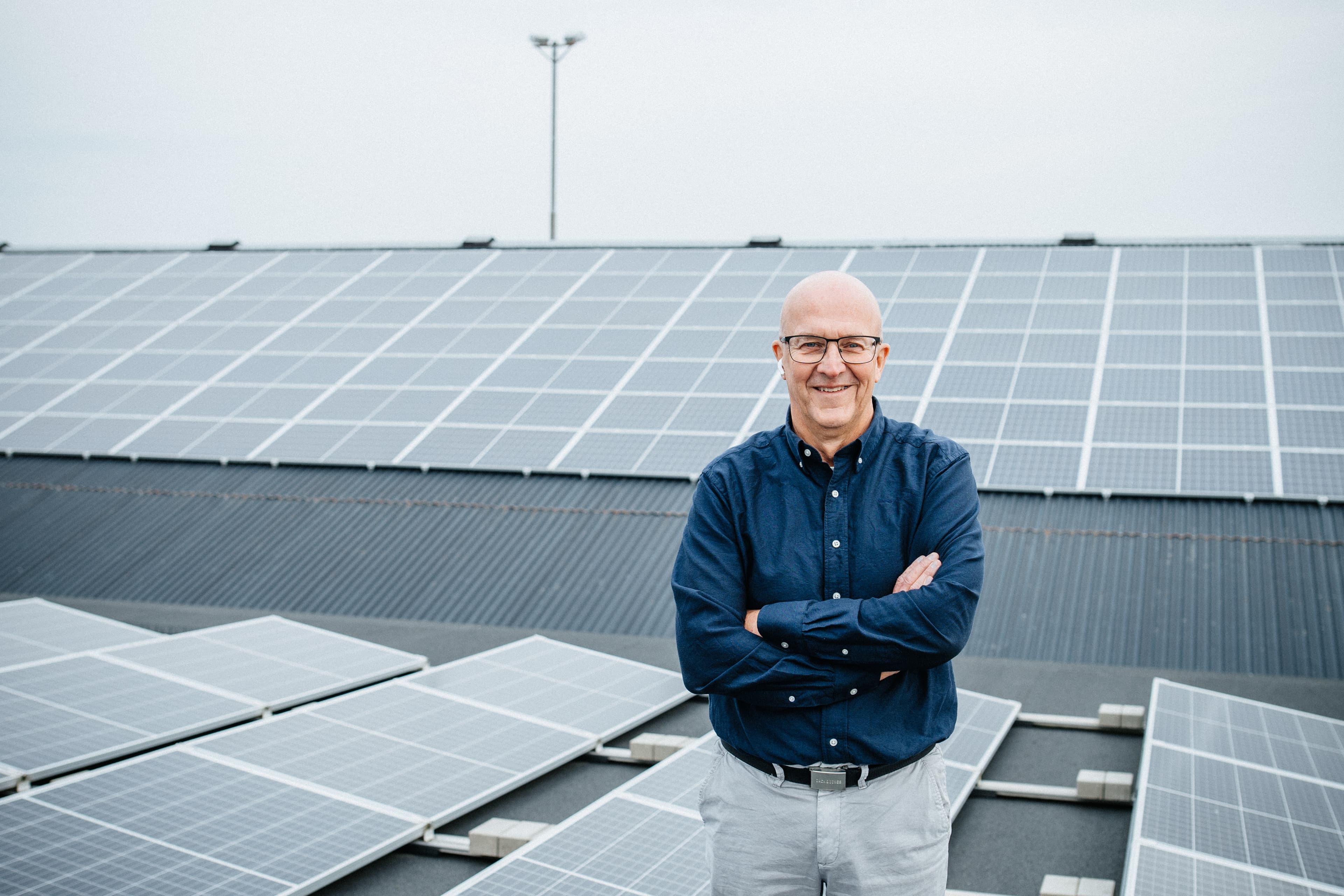 Man står framför solpaneler på taket