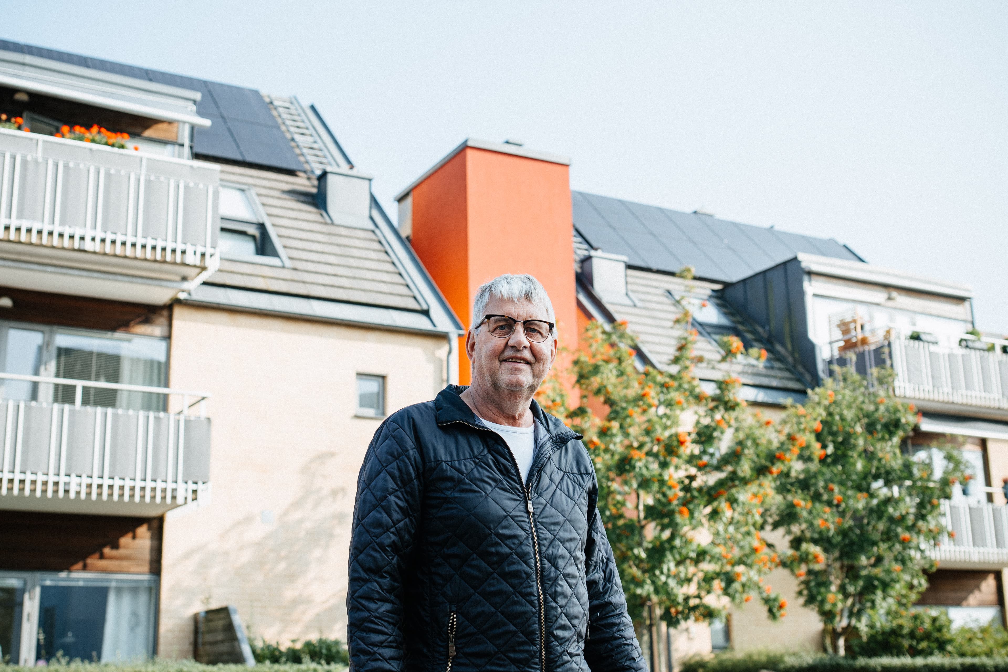 Man som står framför ett hus med solpaneler på taket